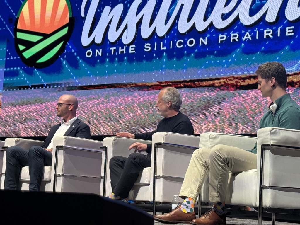Victor Winter, professor of computer science at the University of Nebraska at Omaha and deputy director of AI-CCORE, gestures while speaking during “The Human Element of AI Adoption” panel at Insurtech on the Silicon Prairie 2026, with fellow panelists seated beside him.