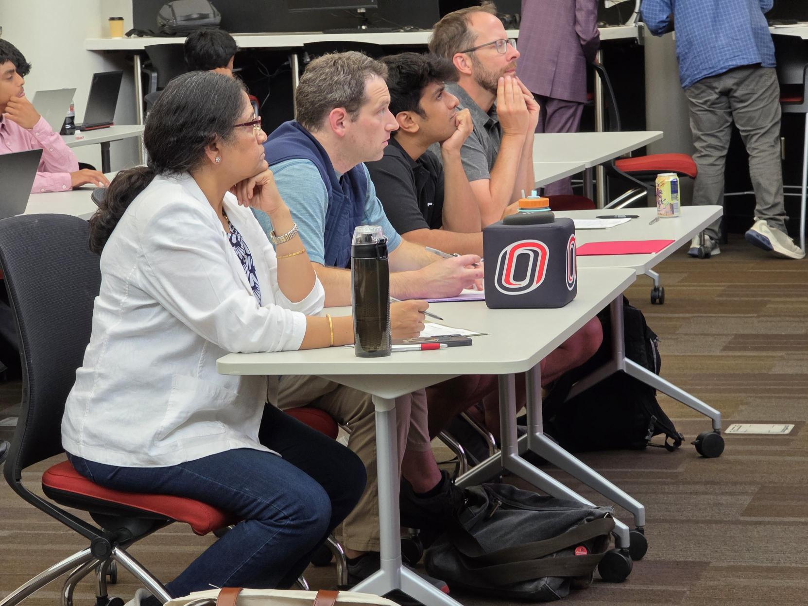 Judges listening to high school student presentations.